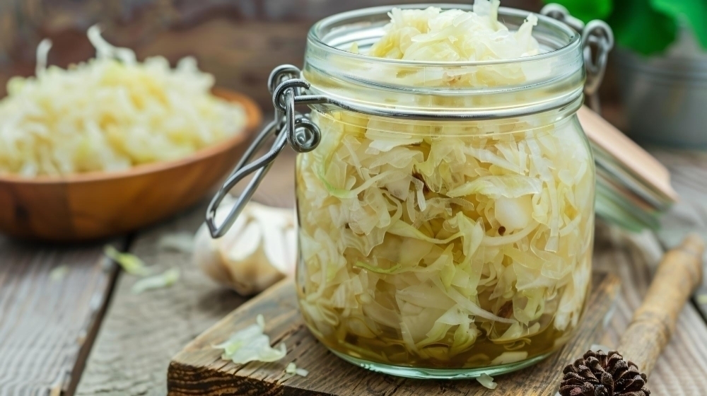 A jar of shredded cabbage is filled with onions