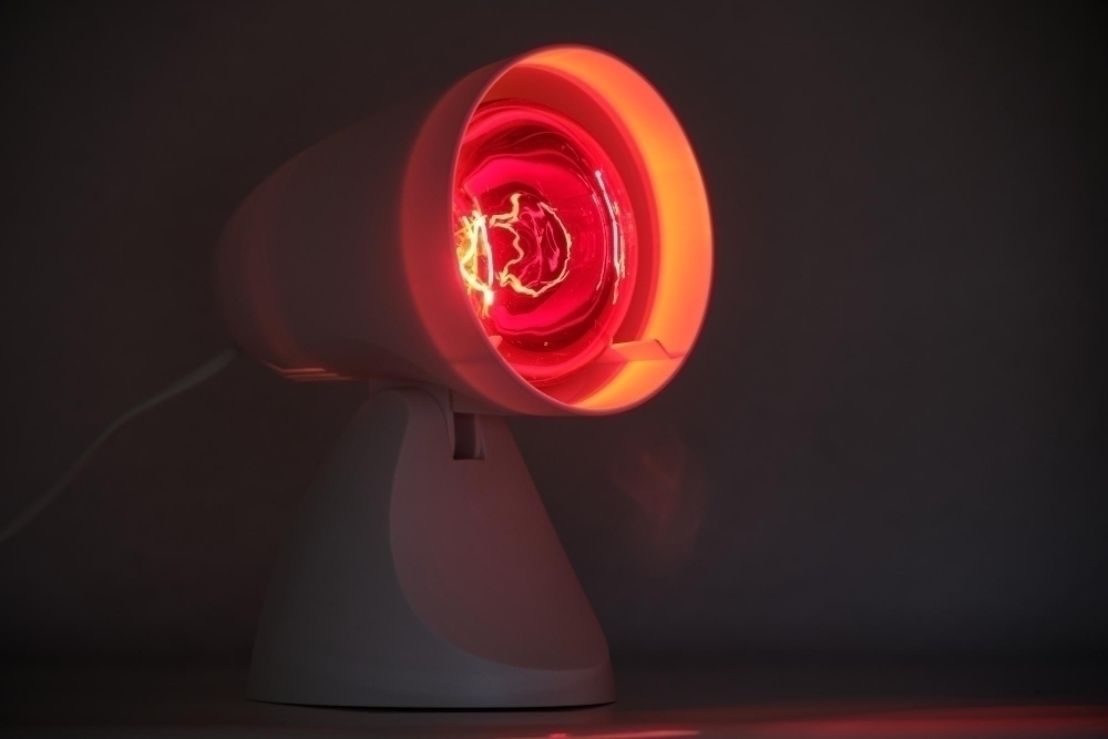 Close up of illuminated infrared lamp against black background