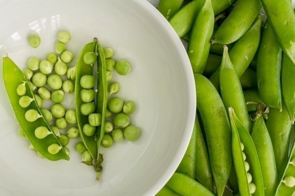 Flat lay pea podsrich in thiamine with bowl
