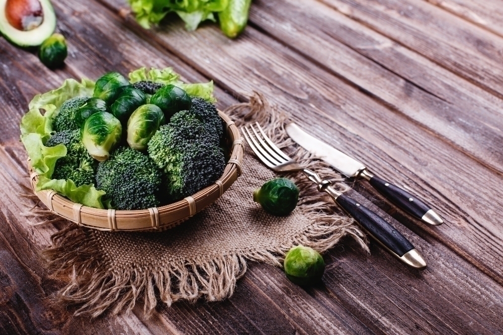 Fresh and healthy food. Wooden bowl with broccoli brussel sprouts olive oil green pepper