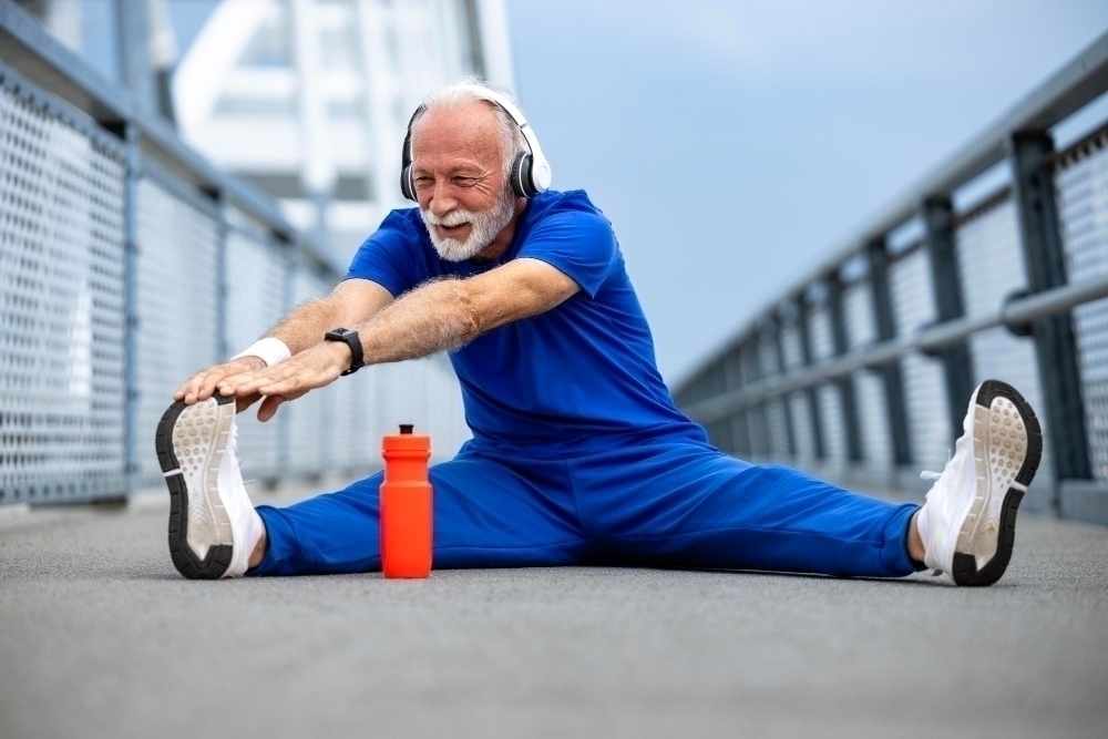 Senior person in sportswear preparing for training and warming up his body