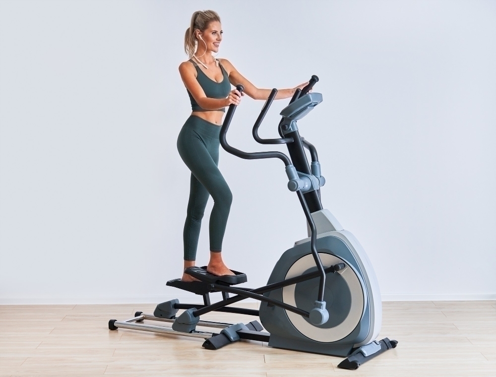 Woman exercising on x trainer in fitness studio