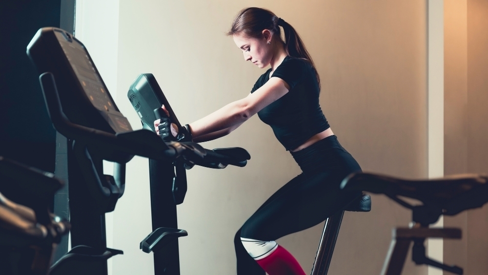 en kvinna sitter pa motionscykel