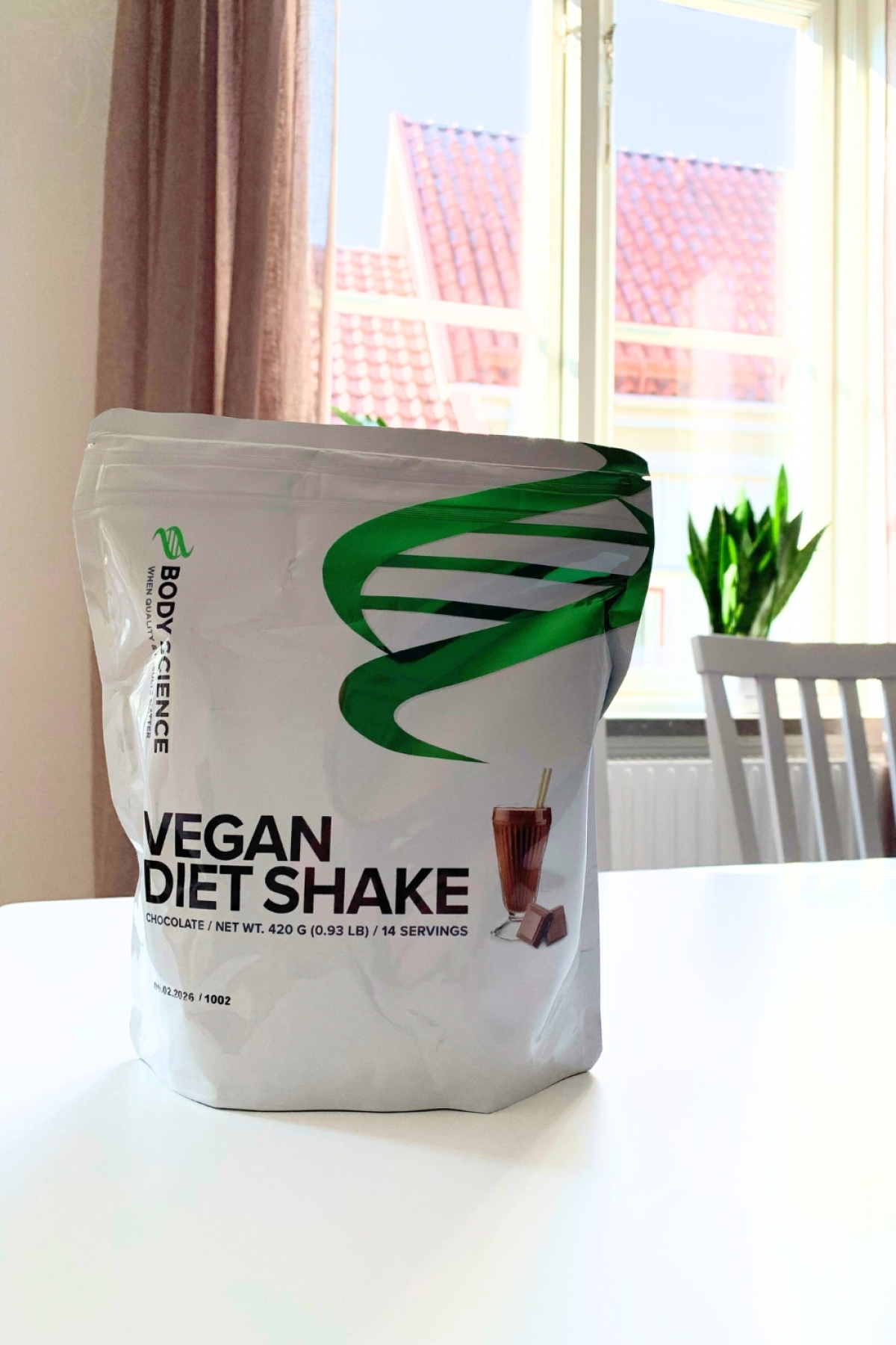 Body Science Vegan Diet Shake Chocolate på köksbordet i morgonljus, foto taget av oss under testet