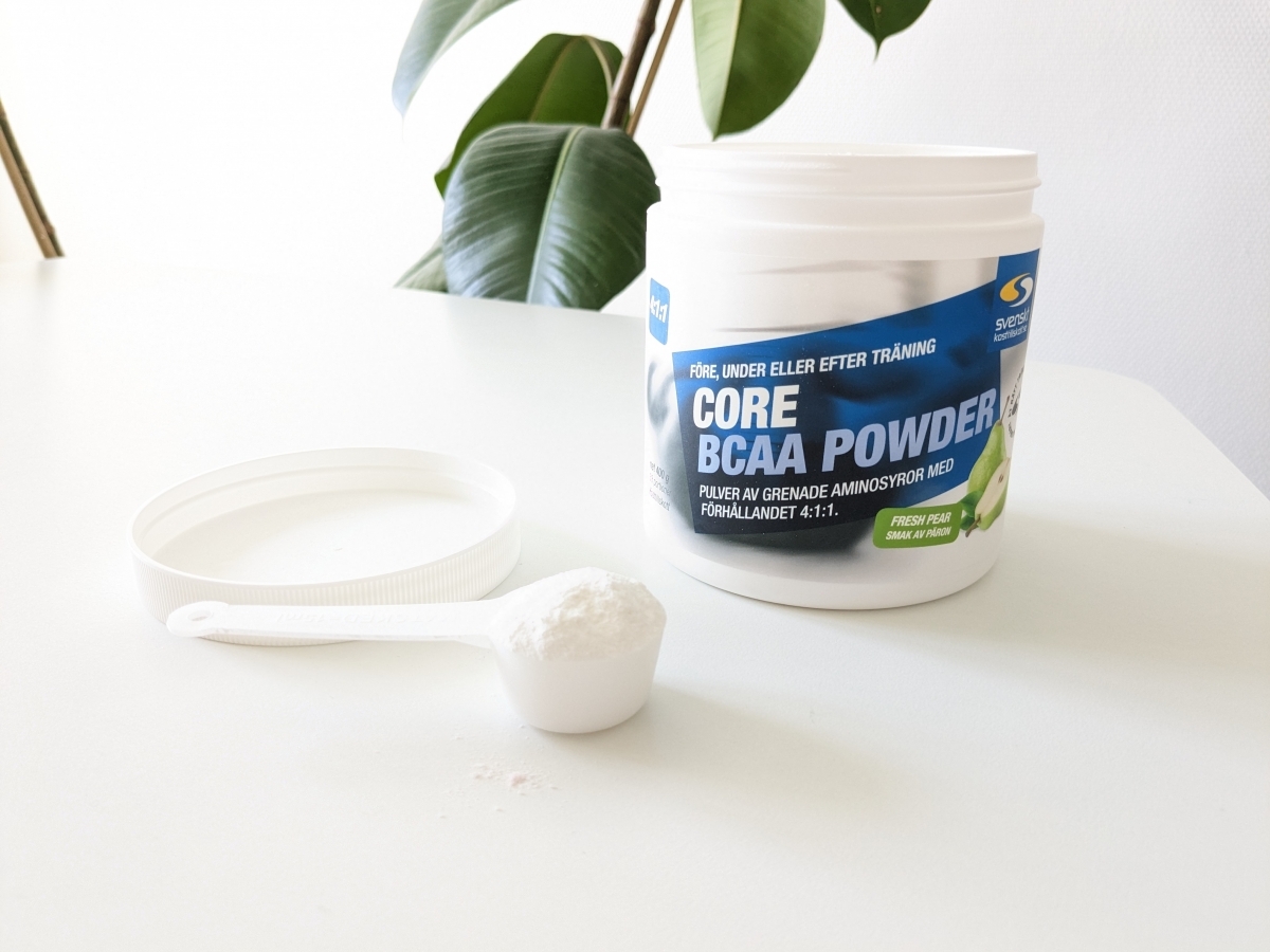 Core BCAA Powder och skopa på vårt bord i naturligt ljus, fotat av oss