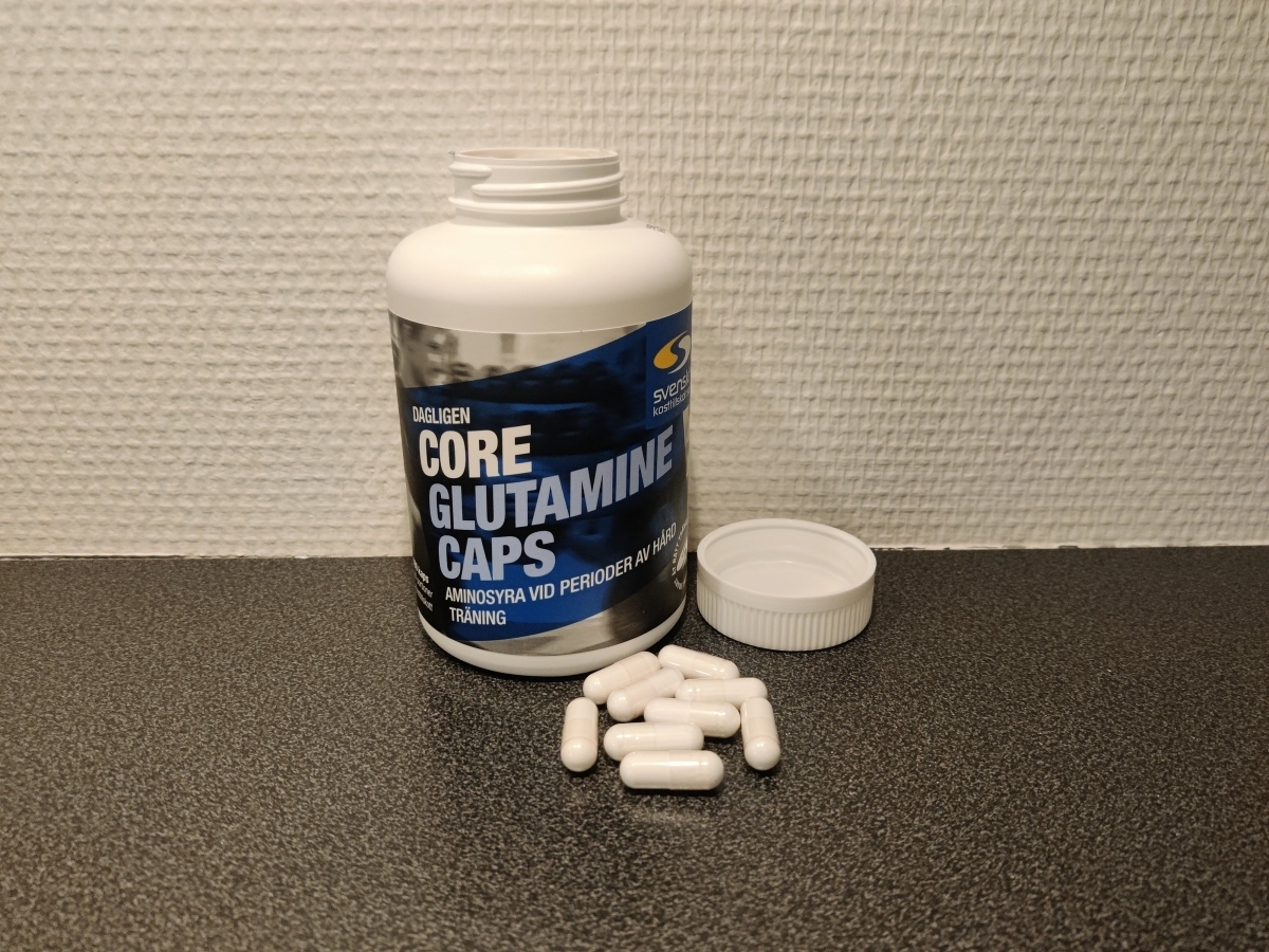 Öppen burk Core Glutamine Caps med kapslar på bänken, egen bild