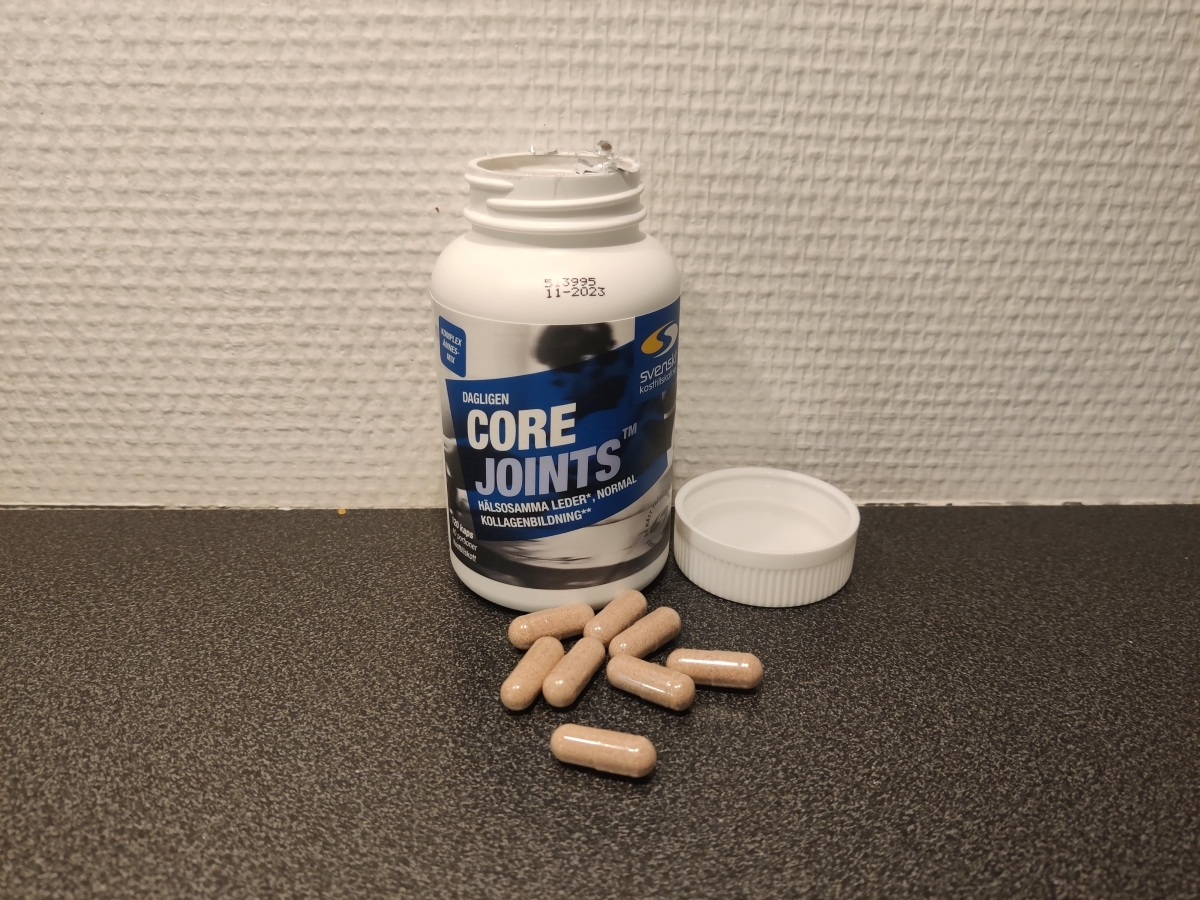 Öppen burk och kapslar av Core Joints på köksbänken foto av oss