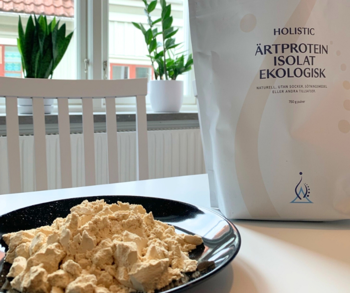 Ärtproteinpulver redo att blandas med förpackningen i bakgrunden, foto från vårt kök