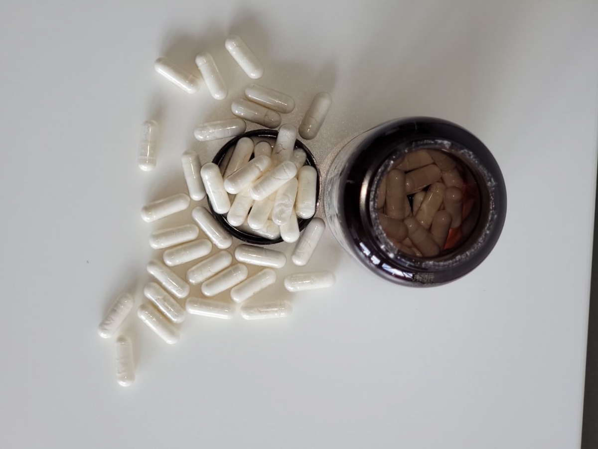 Top-down vy av Närokällan D3 5000 Vegan med spridda kapslar och öppen flaska, fotograferad av oss
