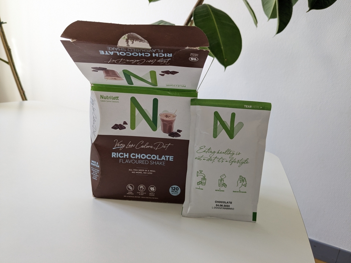 Nutrilett Rich Chocolate kartong med fristående portionspåse på bord tagen av oss
