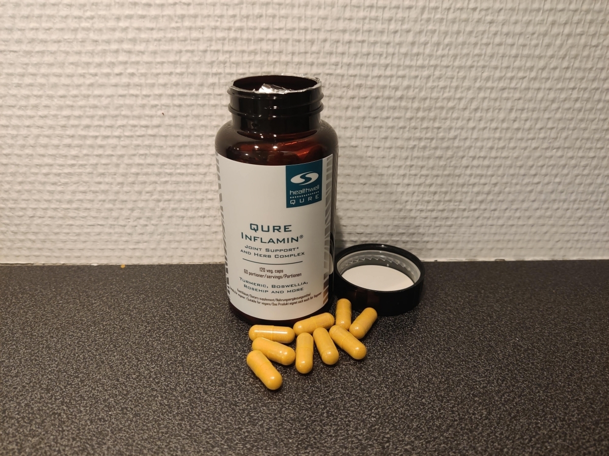 Öppen burk med Inflamin Premium och kapslar på köksbänken, fotad av oss