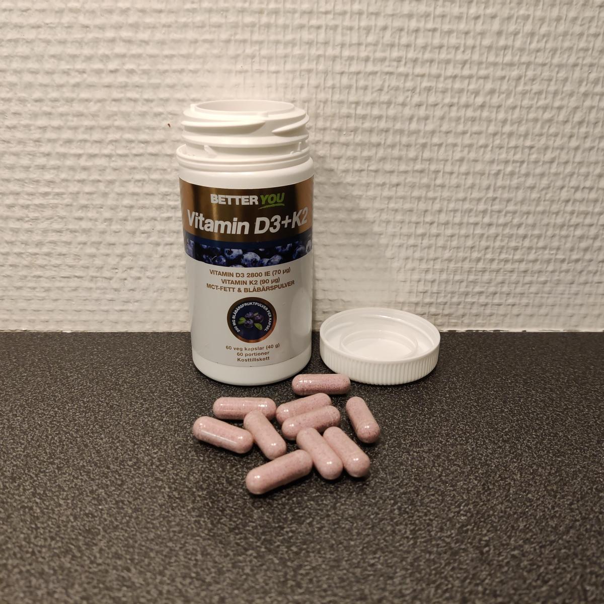 Better You Vitamin D3+K2 på träbord med kapslar bredvid locket fotograferad av oss