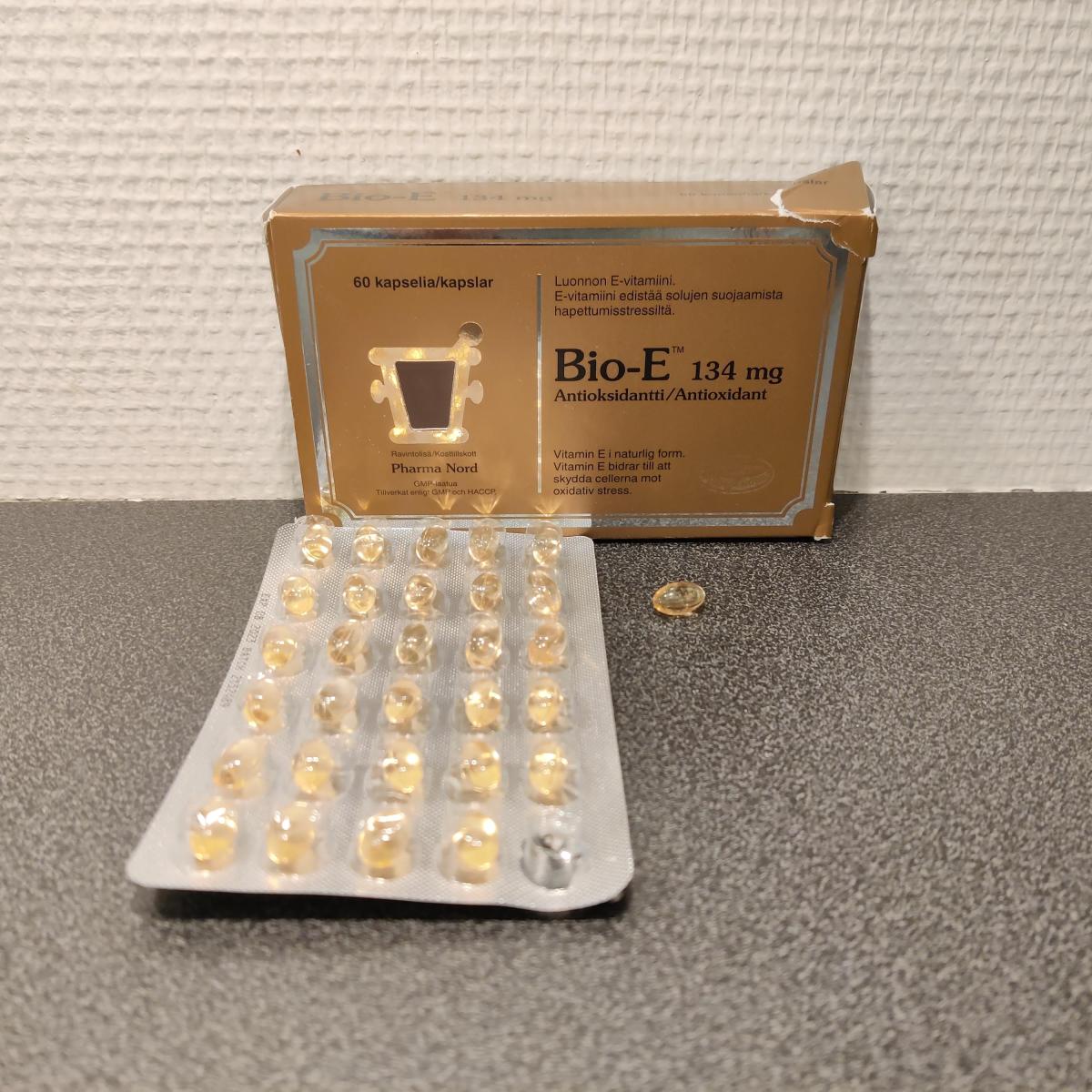 Bio-E-Vitamin på träbord med öppnat blister, flera kapslar redan använda