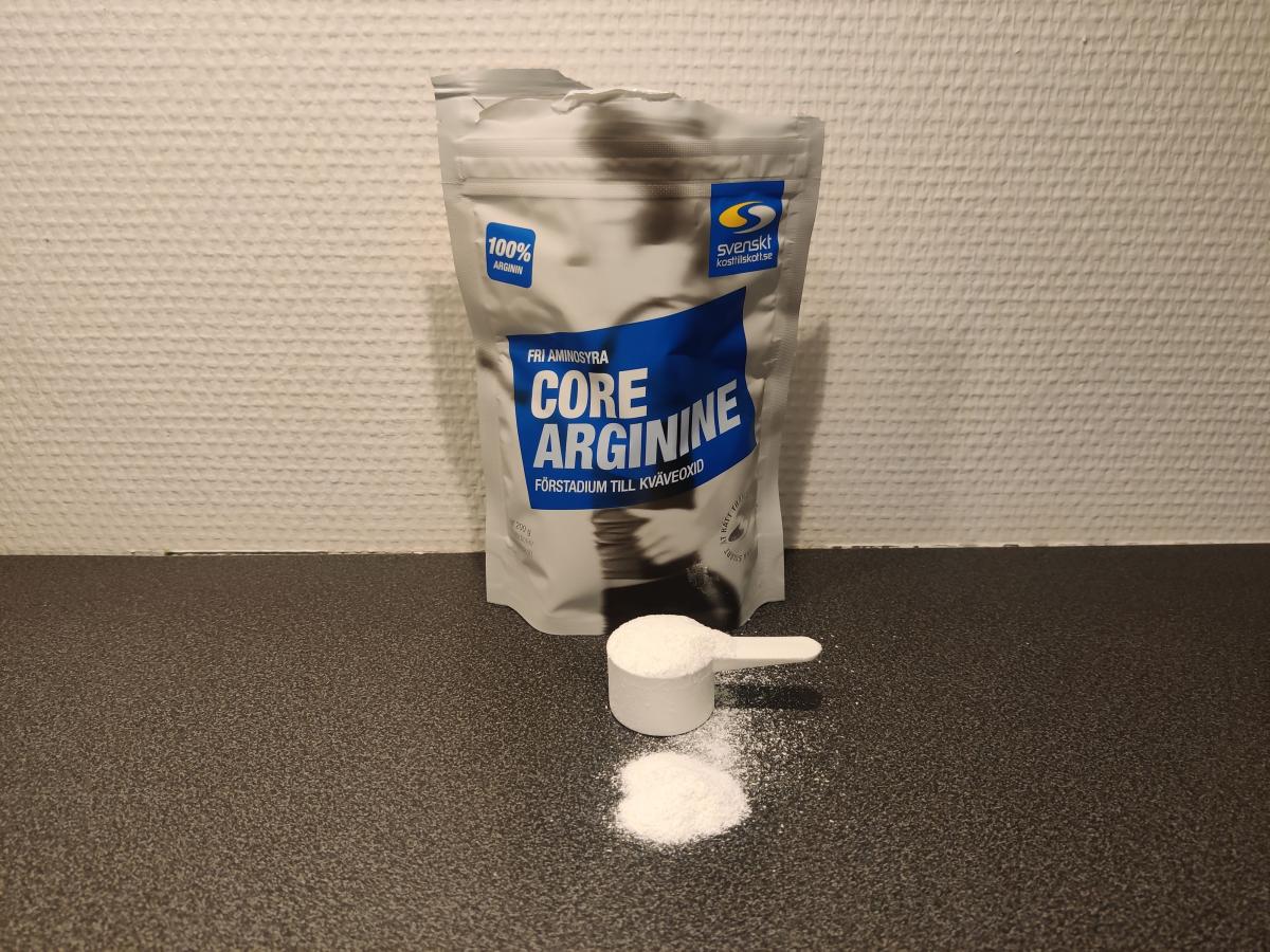 Core Arginine med skopa och fint pulver på köksbänken