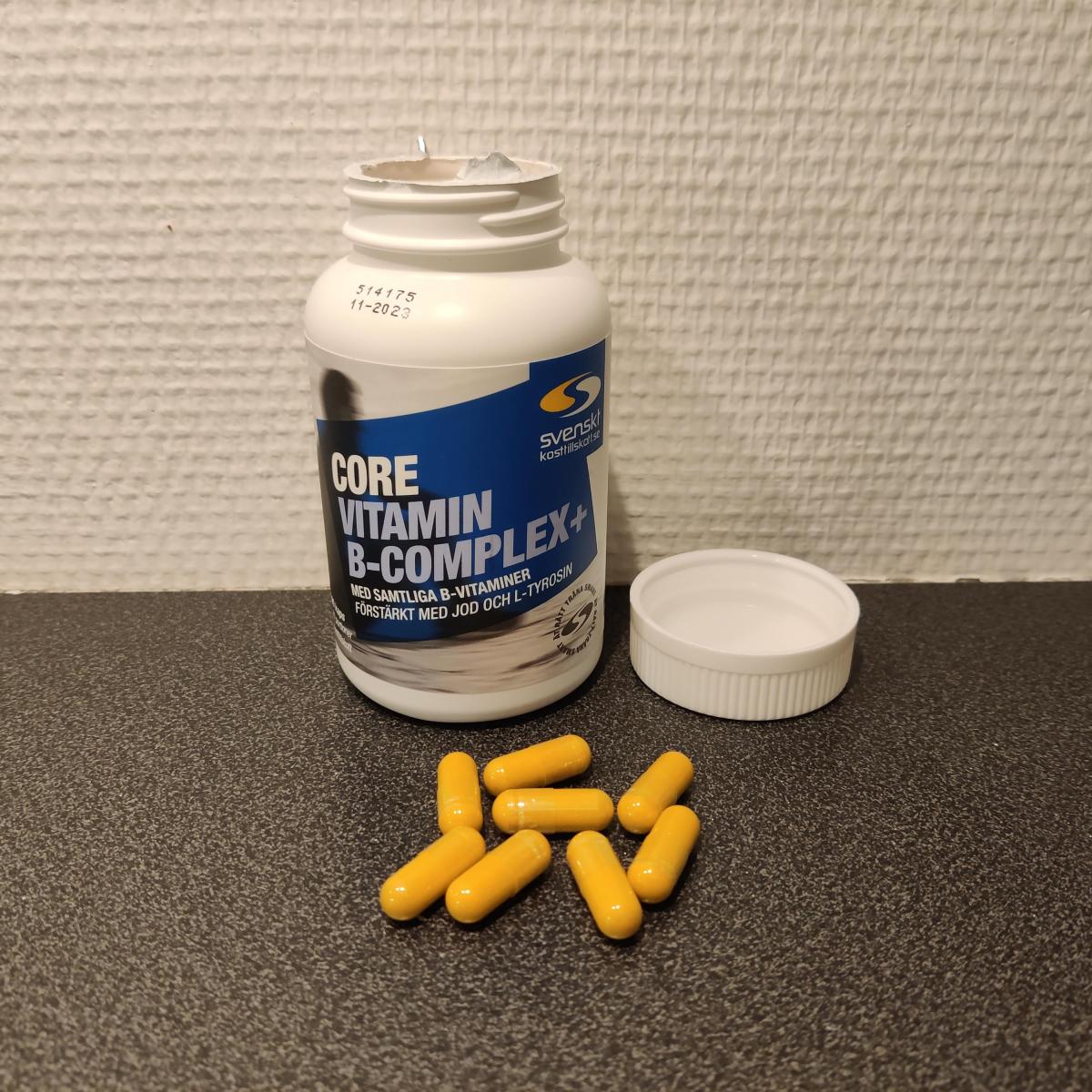 Öppen burk Core Vitamin B-Complex+ med gula kapslar på bänken, foto taget av oss under testet
