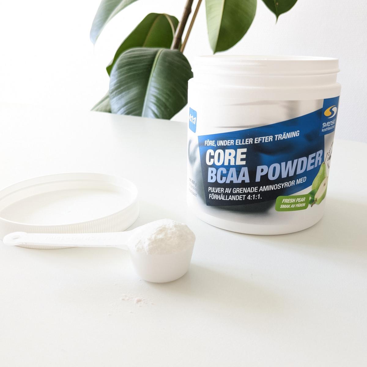 Core BCAA Powder och skopa på vårt bord i naturligt ljus, fotat av oss