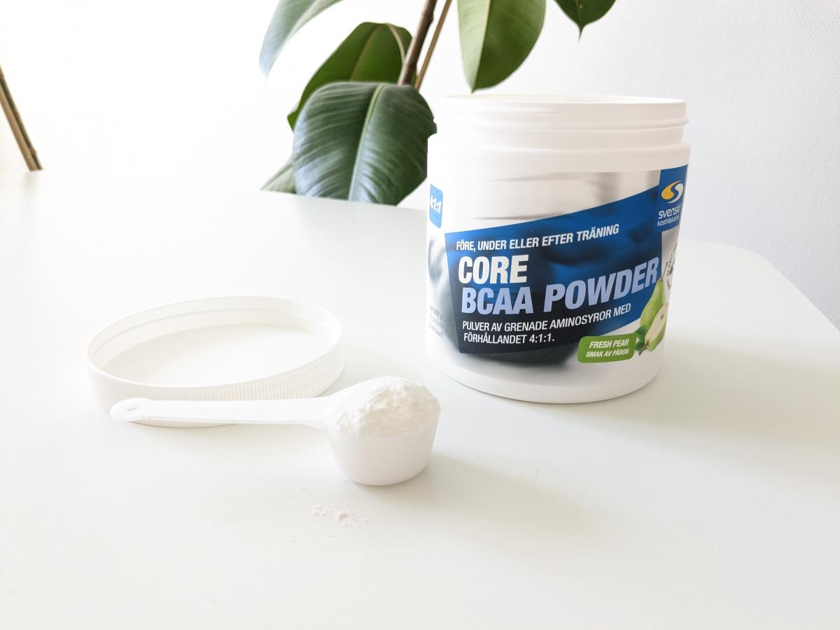 Core BCAA Powder och skopa på vårt bord i naturligt ljus, fotat av oss