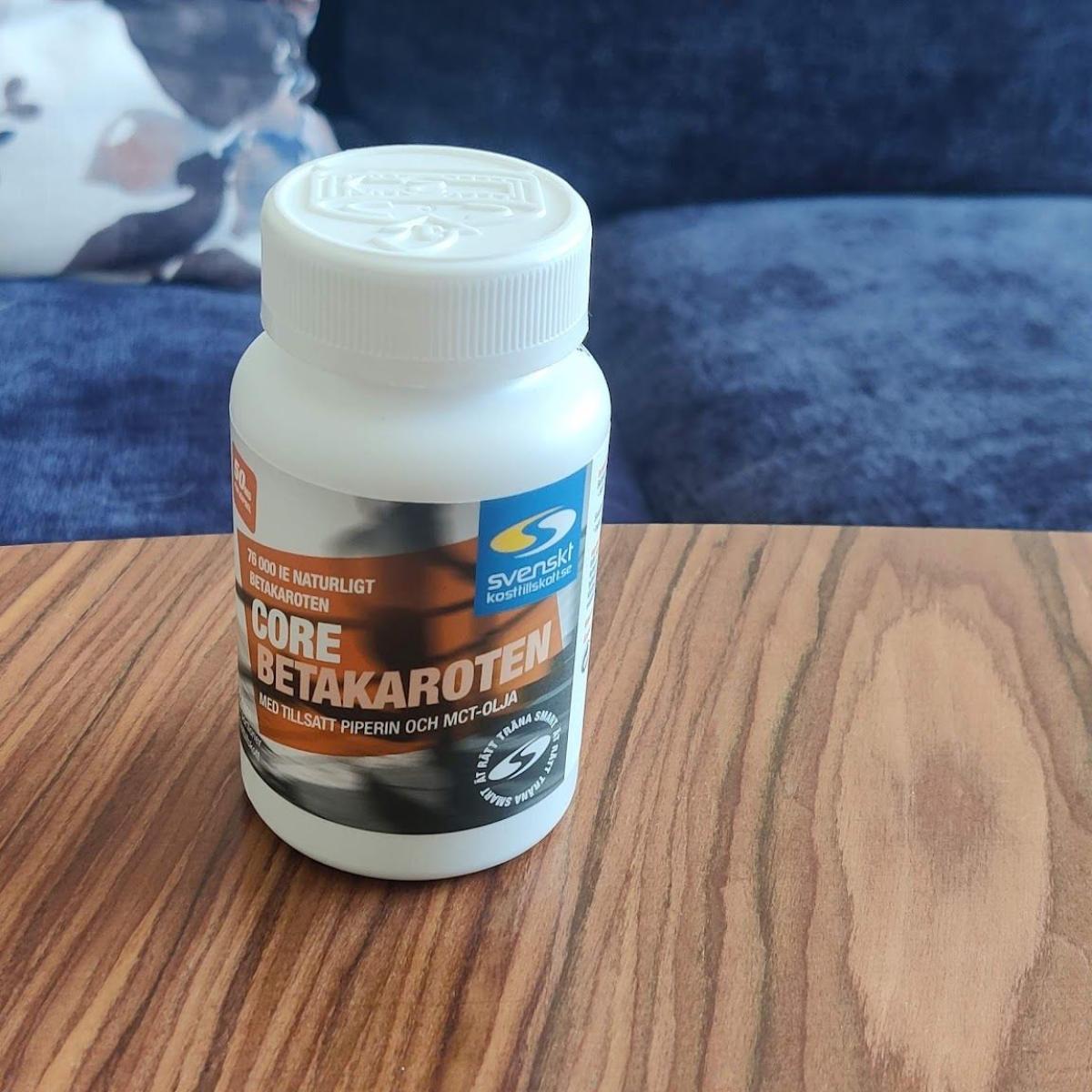 Core Betakaroten-burk med två kapslar på tyg, foto taget av oss