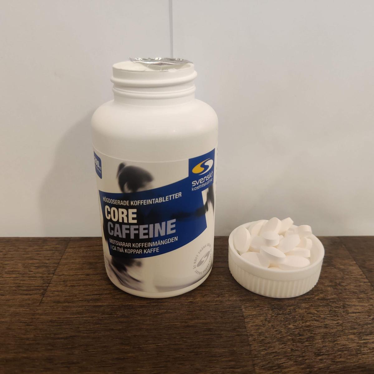 Core Caffeine öppnad burk med vita tabletter bredvid, fotad i vårt test