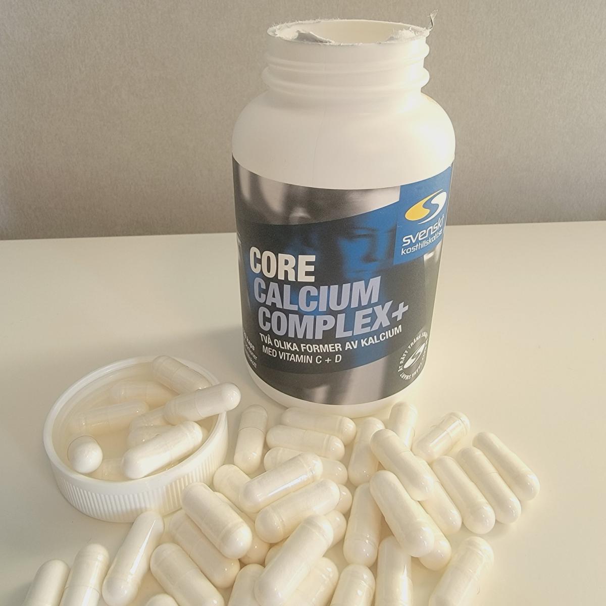 Core Calcium Complex+ öppnad burk med kapslar utspridda på bordet, foto taget av oss under testet