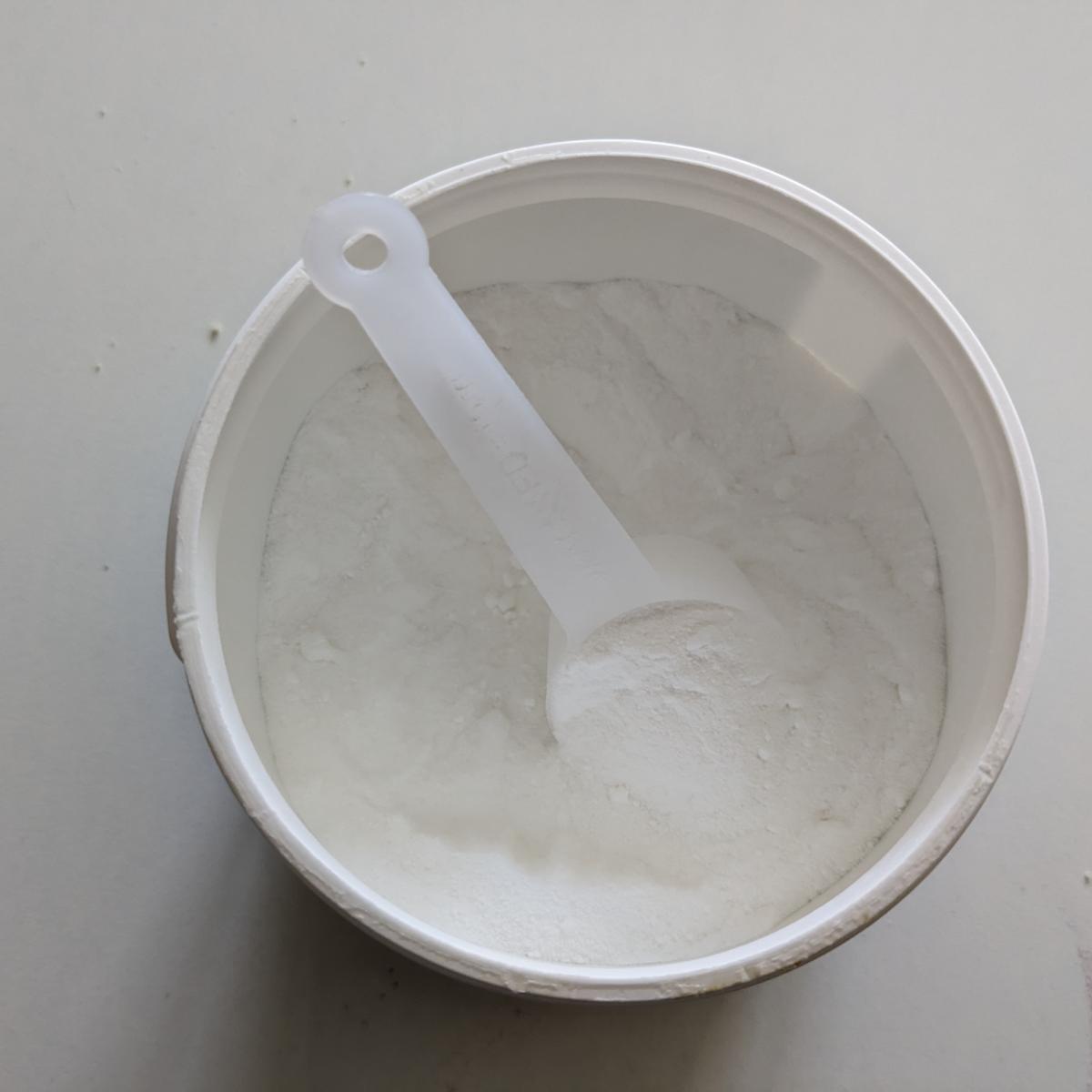 Öppnad burk Core Creatine Pro med skopa i mjölfint pulver fotad i vårt test