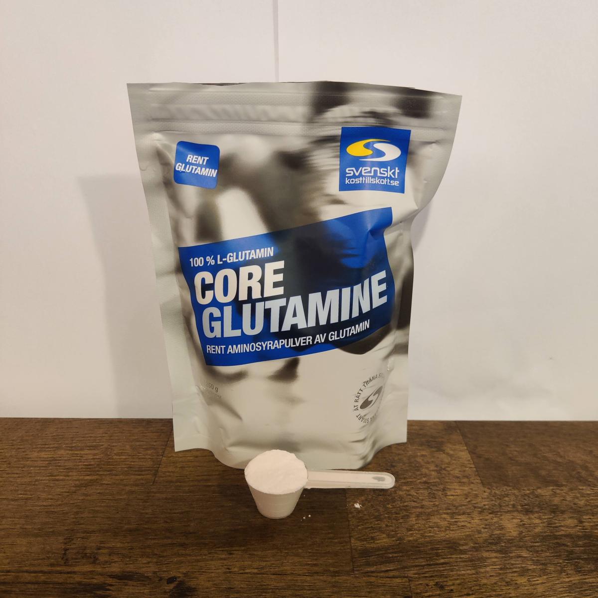 Core Glutamine och skopa på träbord i varmt kvällsljus, vår egen bild