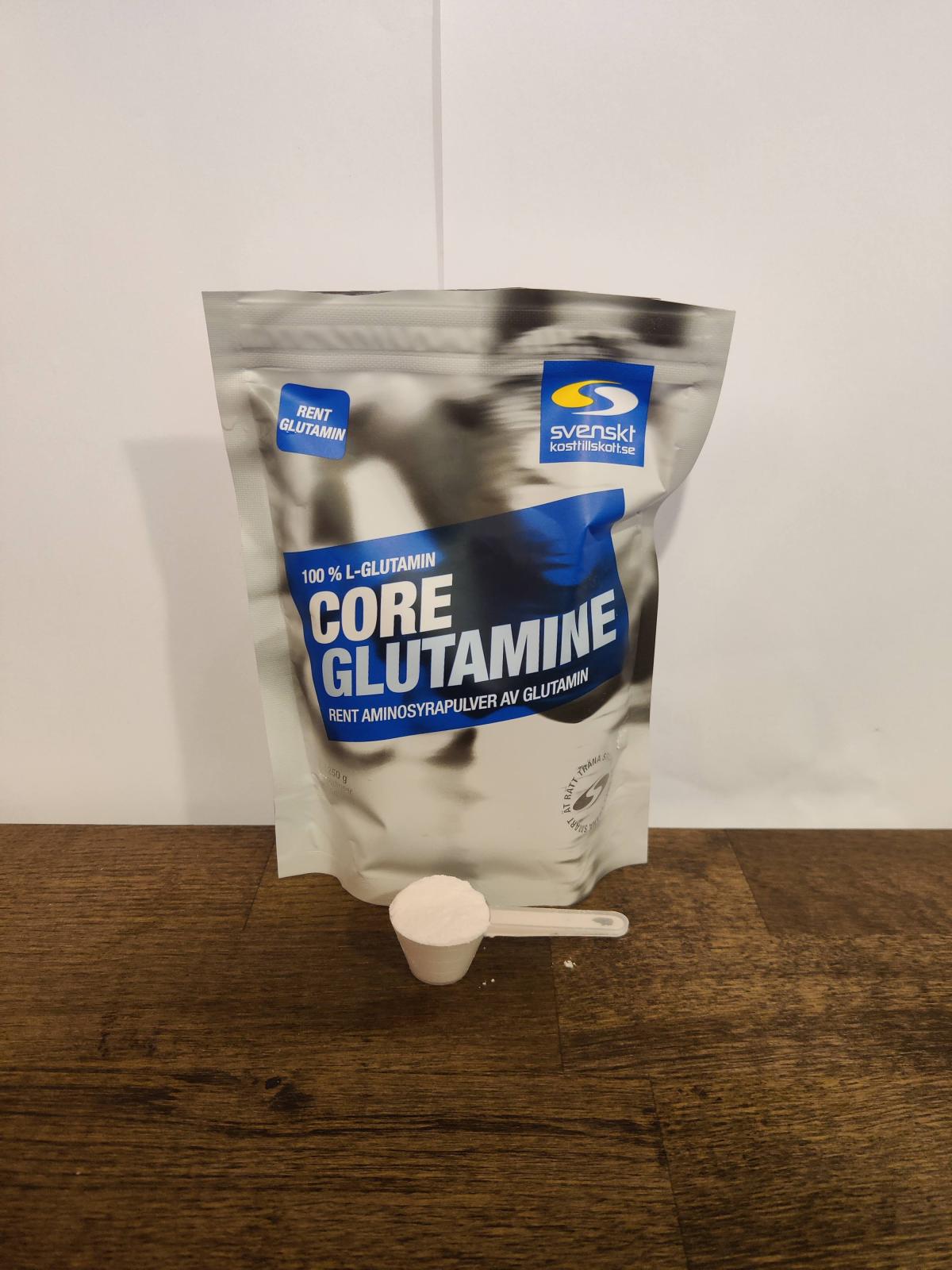 Core Glutamine och skopa på träbord i varmt kvällsljus, vår egen bild