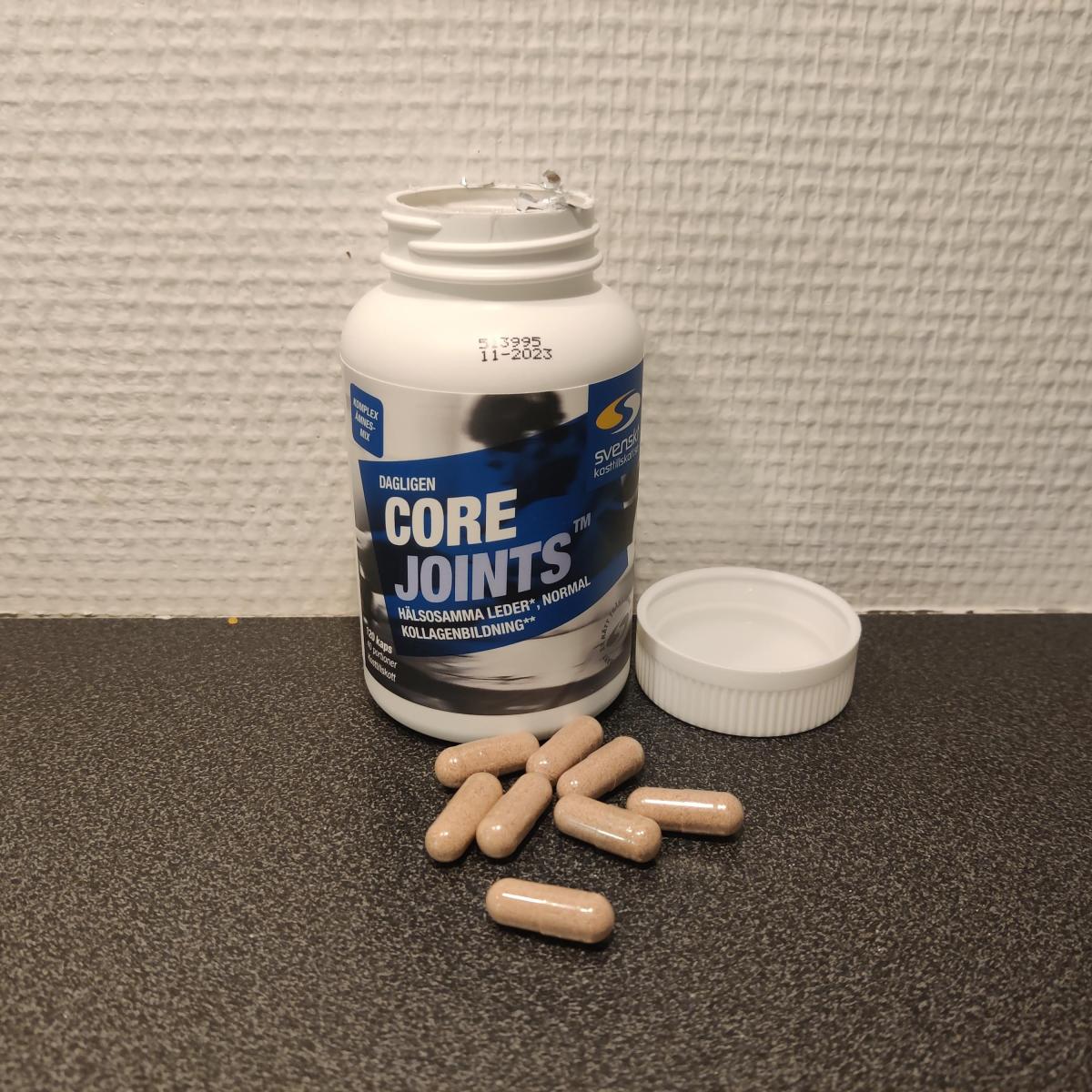 Öppen burk och kapslar av Core Joints på köksbänken foto av oss