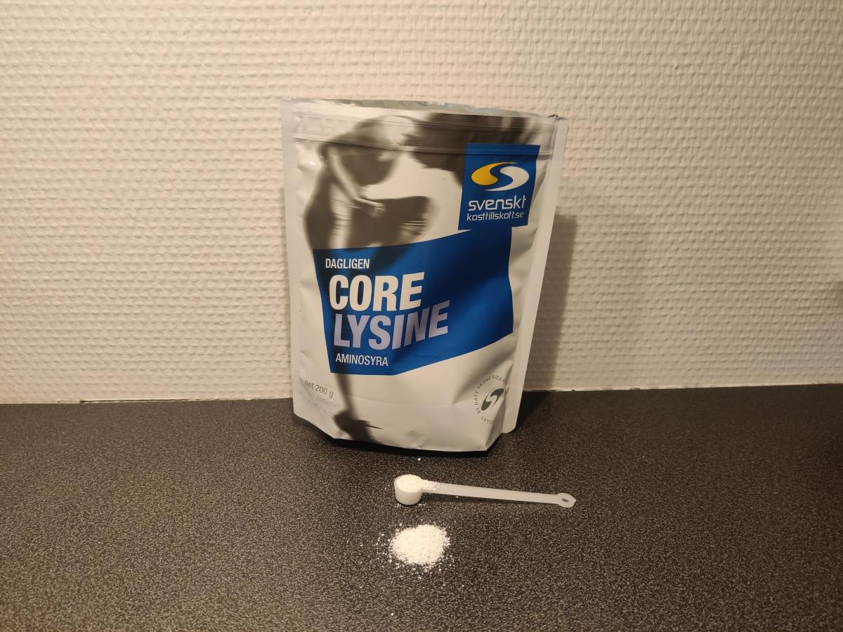 Skopa med vitt Core Lysine‑pulver framför förpackningen i köket, taget under vårt test