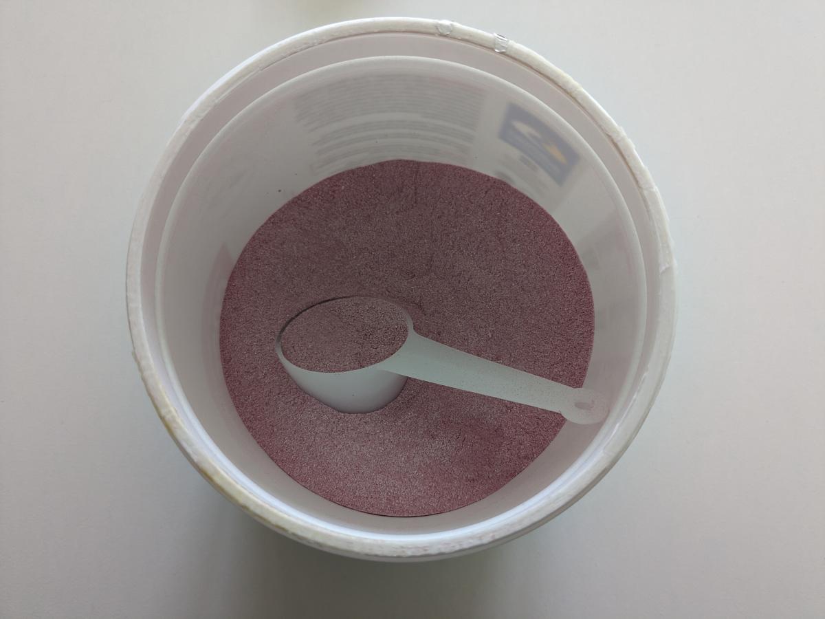 Core Performance BCAA-rikt PWO-pulver i burk med skopa, foto taget av oss under testet