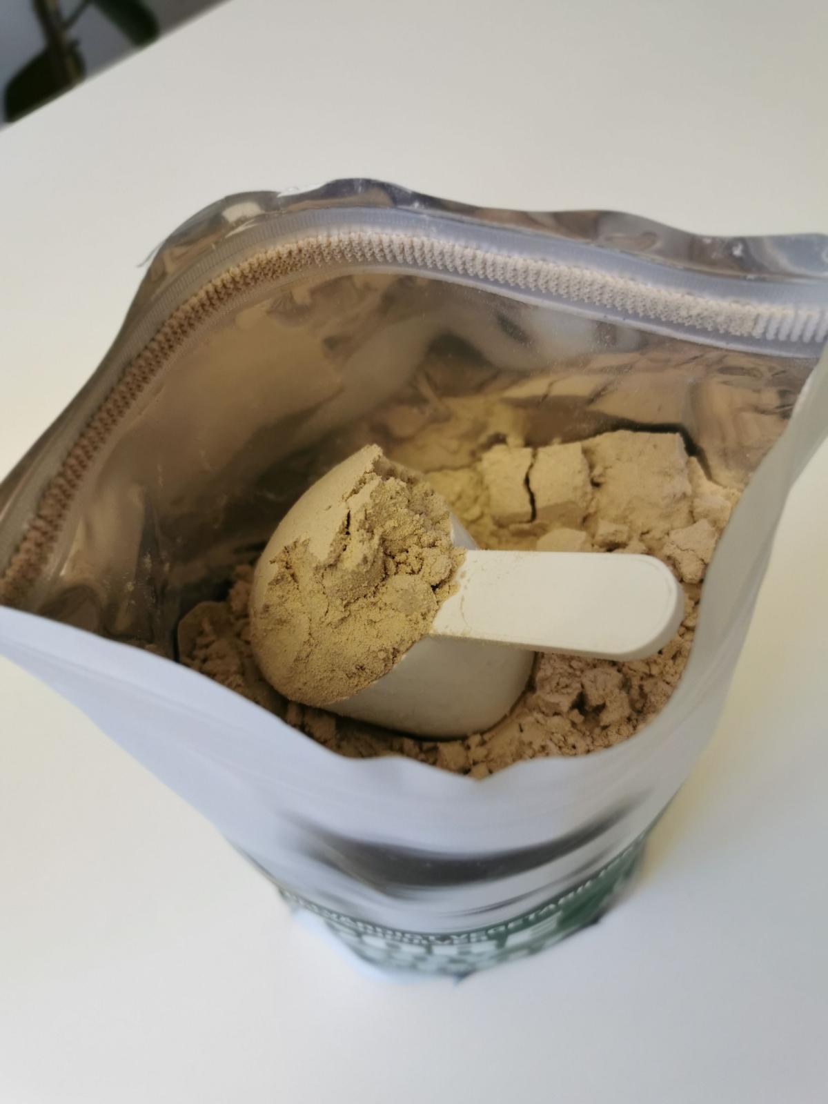 Öppnad påse Core Soy Protein med skopa i pulvret, taget under vårt test
