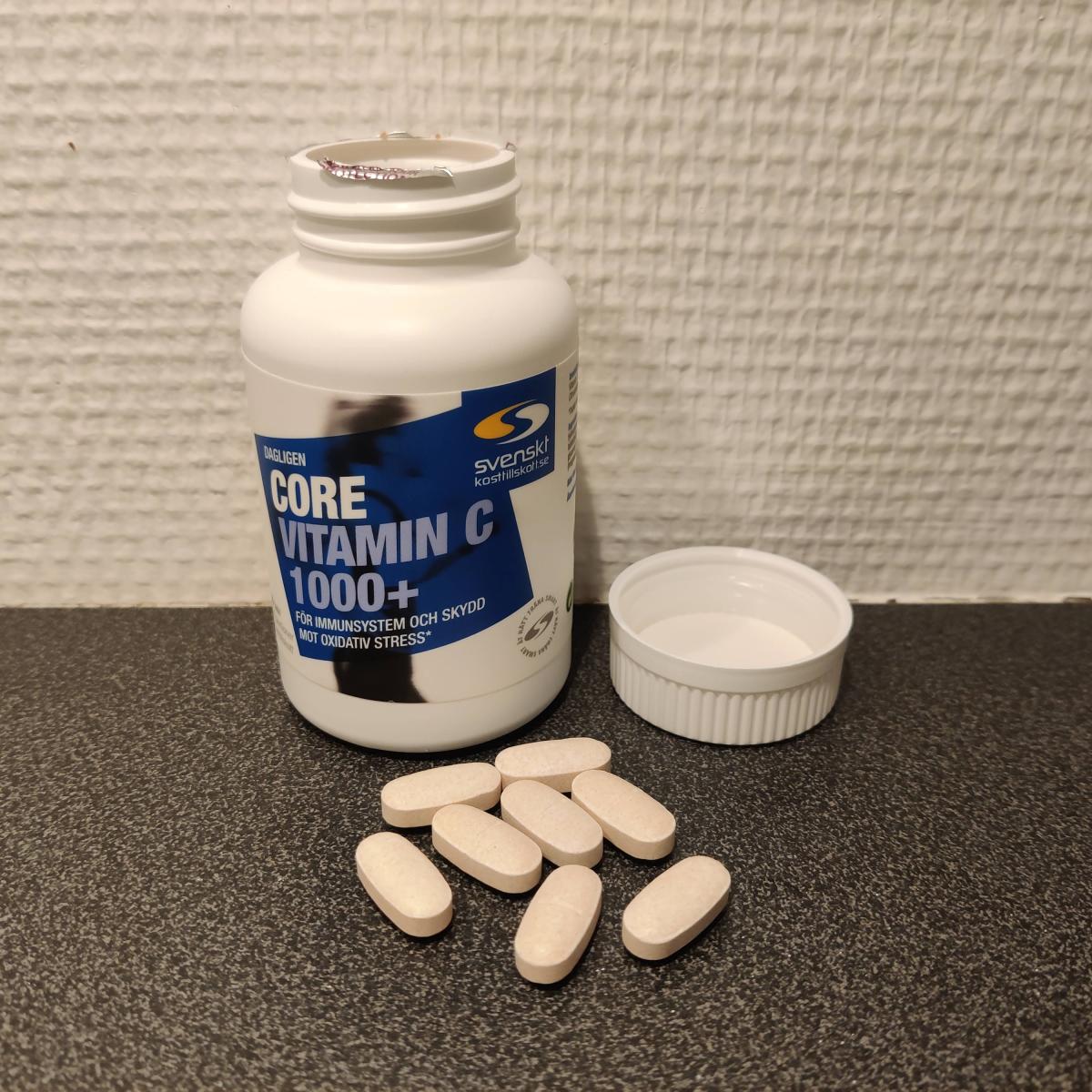 Core Vitamin C på träbord med tabletter bredvid, egen bild