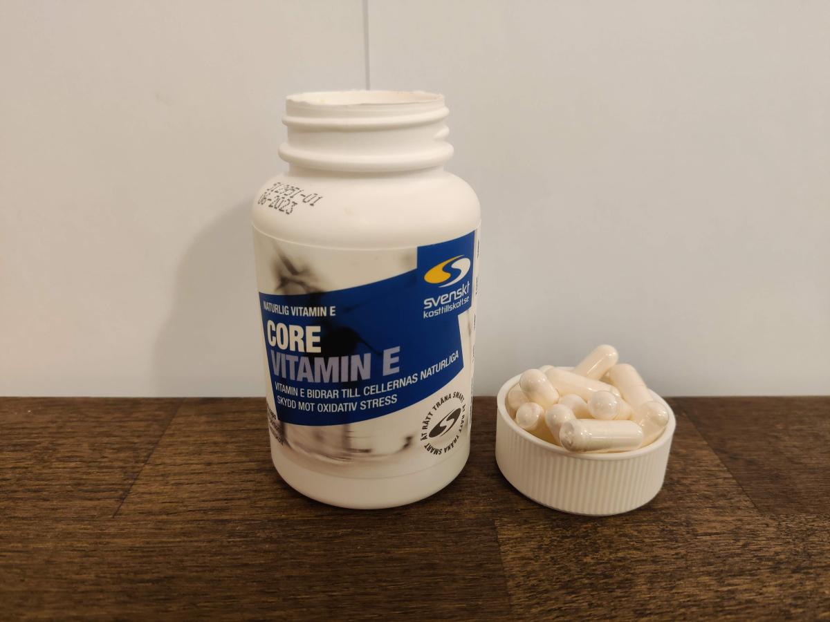 Core Vitamin E burk med flera kapslar intill, foto taget av oss