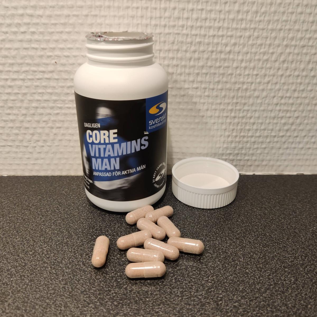 Core Vitamins Man med öppnad burk och kapslar på bänken, foto taget av oss