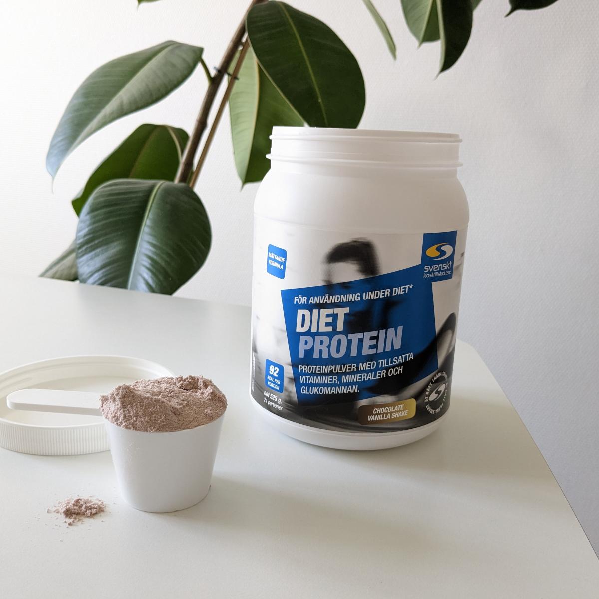 Diet Protein burk och uppmätt skopa på bord i dagsljus, tagen av oss