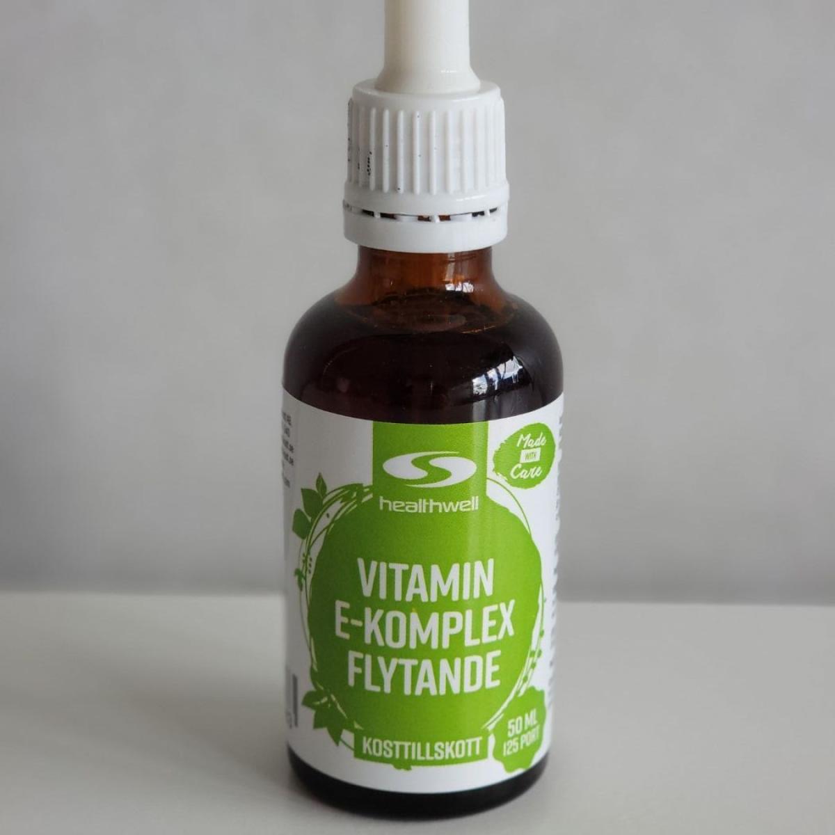 Baksida med innehåll och doseringsinfo för Healthwell Vitamin E Komplex Flytande