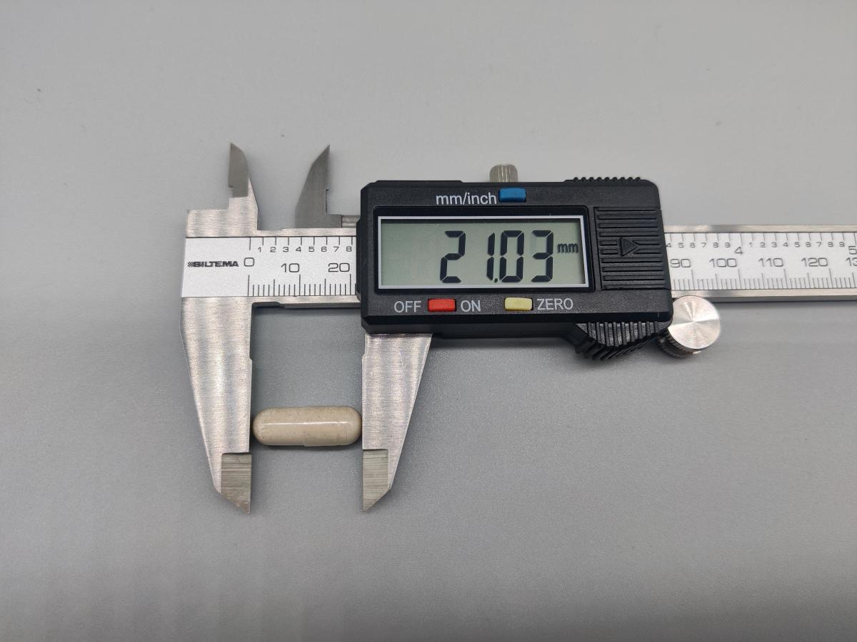 Närbild på kapsel uppmätt till cirka 21 mm med skjutmått