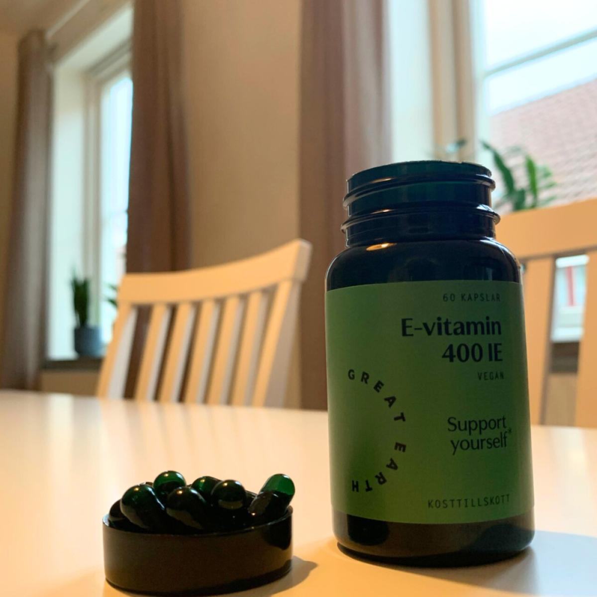 Great Earth E‑vitamin med kapslar utlagda på bordet
