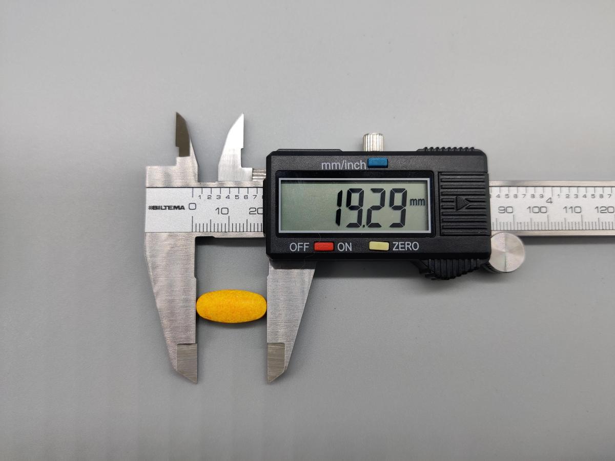 Skjutmått visar 19,29 mm på en tablett av Great Earth Magnesium 375 mg, vårt foto