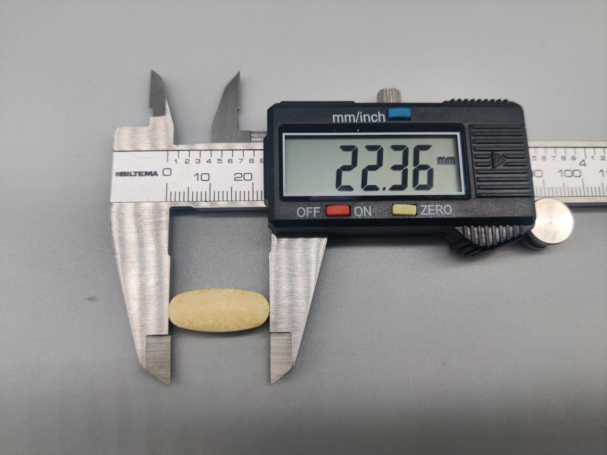 Närbild på tablett uppmätt till 22,36 mm med skjutmått, egen mätning under testet