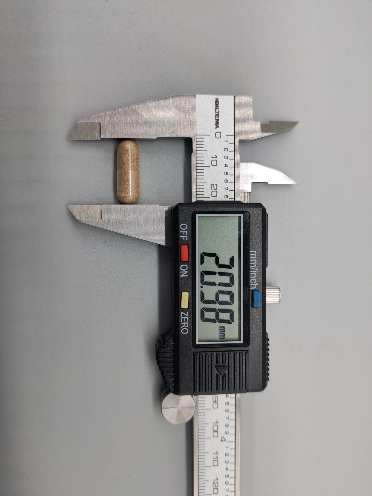 Kapsel från Healthwell Ashwagandha mätt till cirka 21 mm med skjutmått, tagen av oss under testet