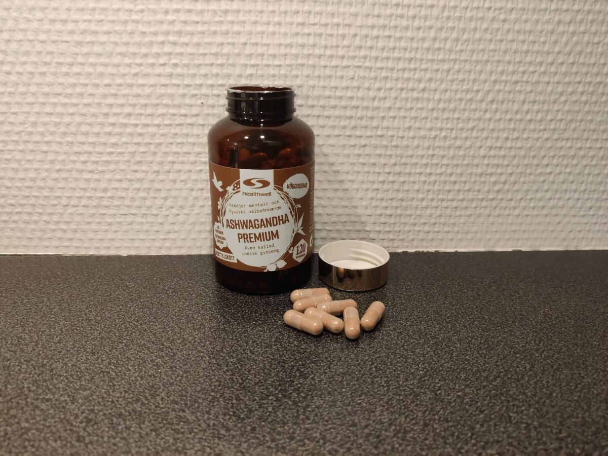 Healthwell Ashwagandha Premium öppnad burk med kapslar på bänken, tagen av oss under testet