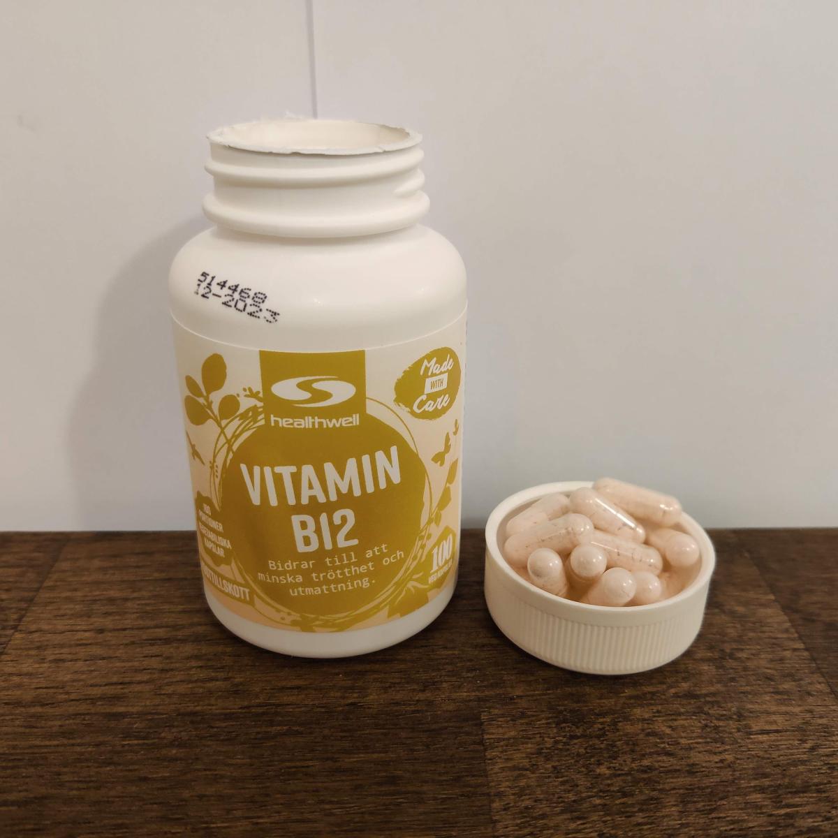 Healthwell B12 med kapslar intill locket på köksbord, egen bild