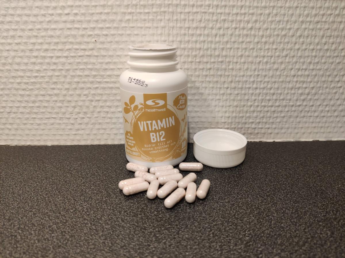Healthwell Vitamin B12 500 Metylerad öppnad burk med kapslar på bänkskiva, foto taget av oss under testet
