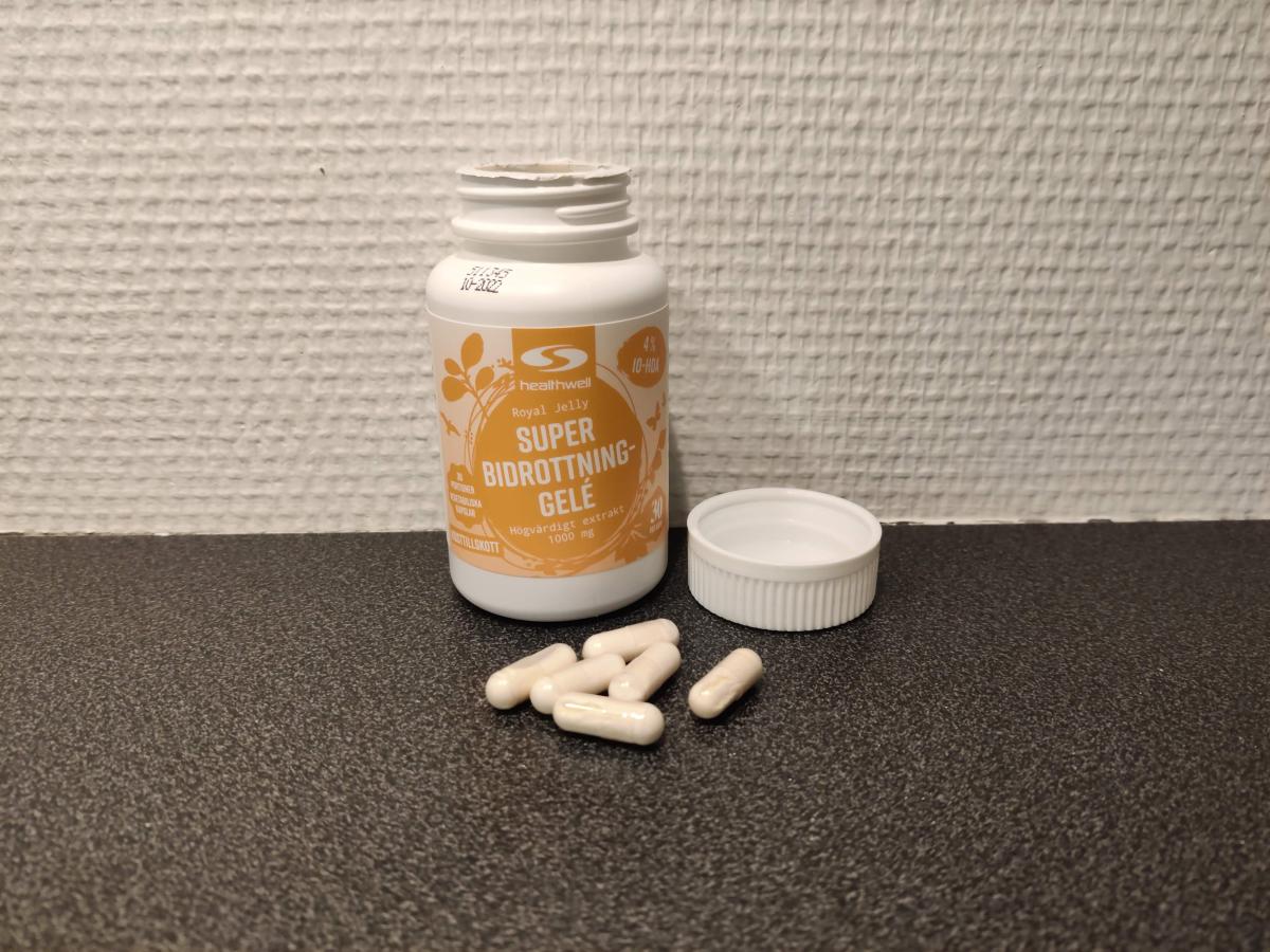Healthwell Bidrottninggelé öppnad burk med kapslar på bänk, fotad av oss under testet