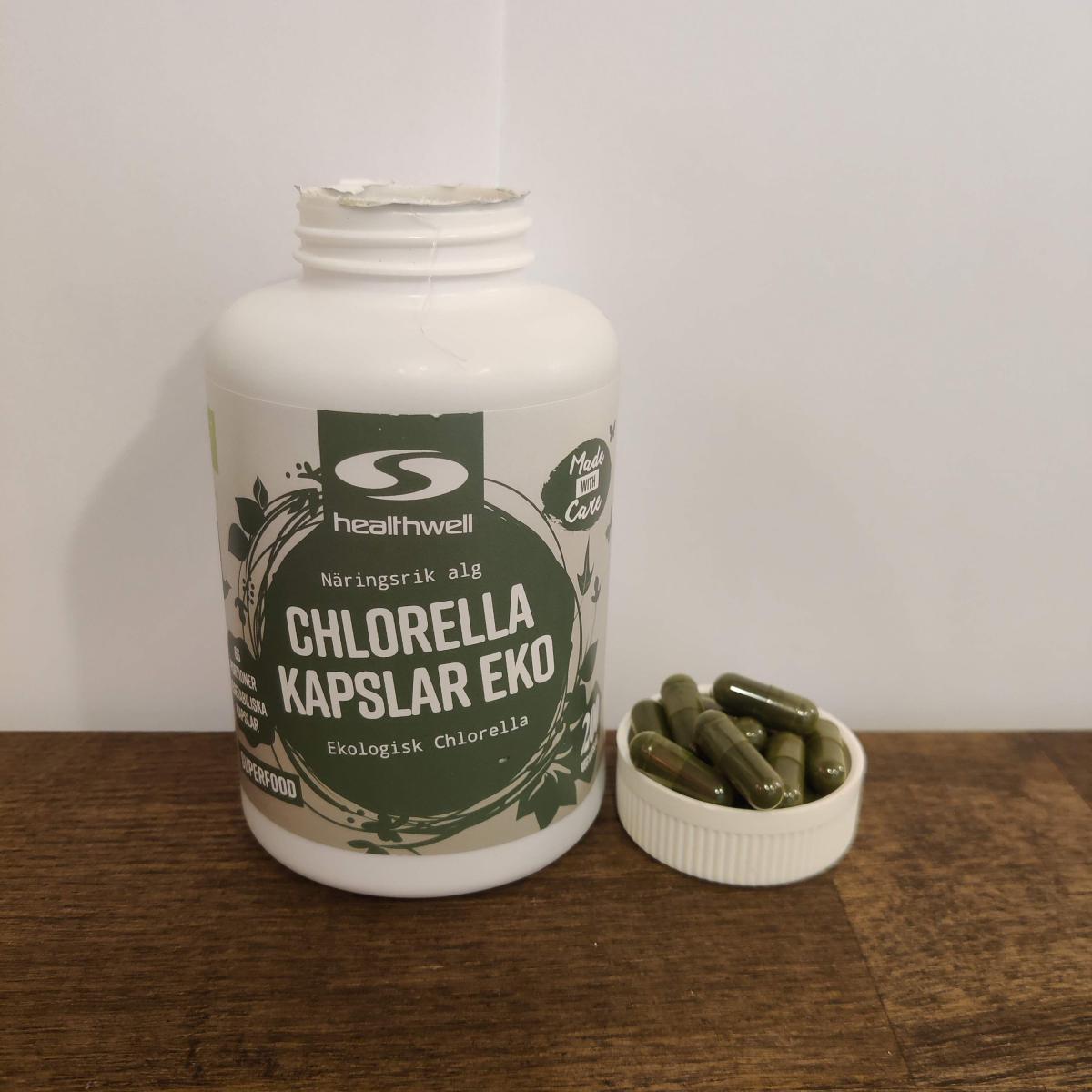 Healthwell Chlorella Kapslar EKO med kapslar på bänkskiva, taget av oss under testet