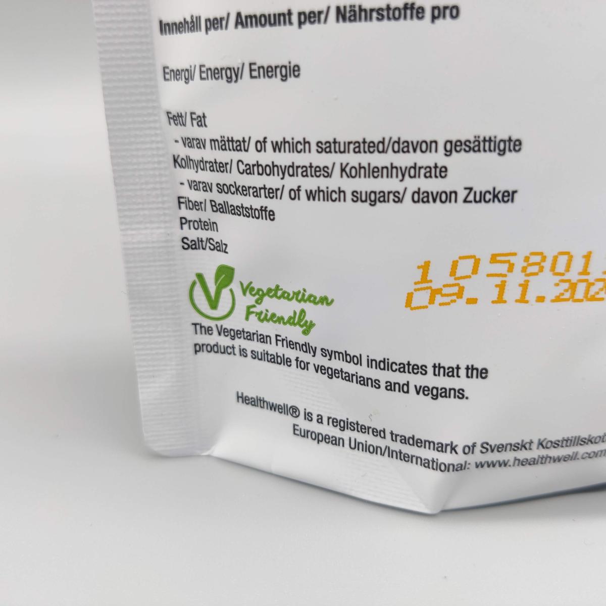 Närbild på vegetarisk märkning och bäst före-datum på Healthwell Detox Tea
