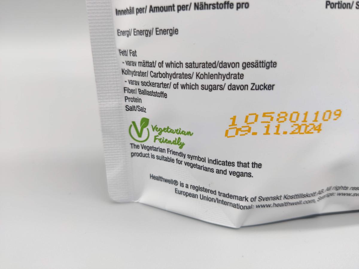 Närbild på vegetarisk märkning och bäst före-datum på Healthwell Detox Tea