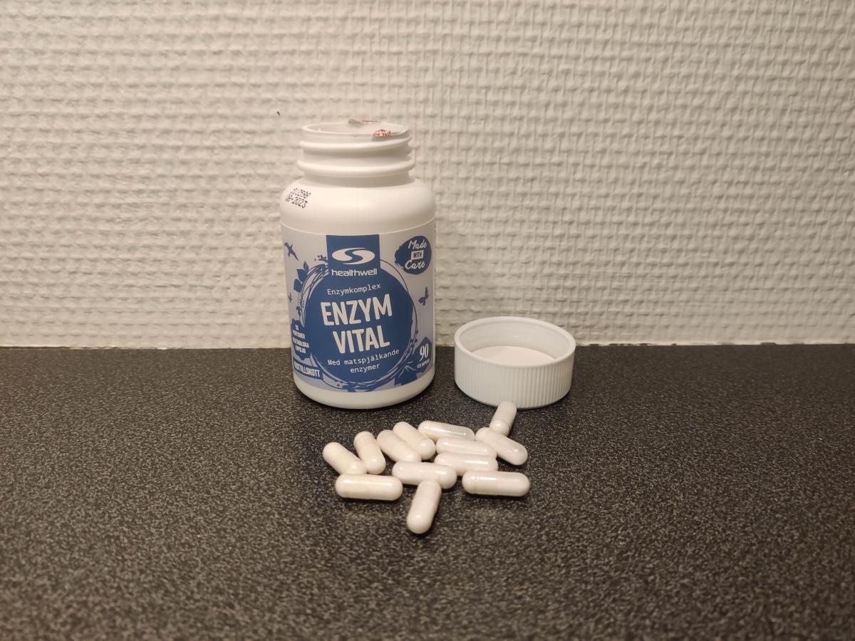 Healthwell Enzym Balans öppnad burk med kapslar på bänken, foto av oss
