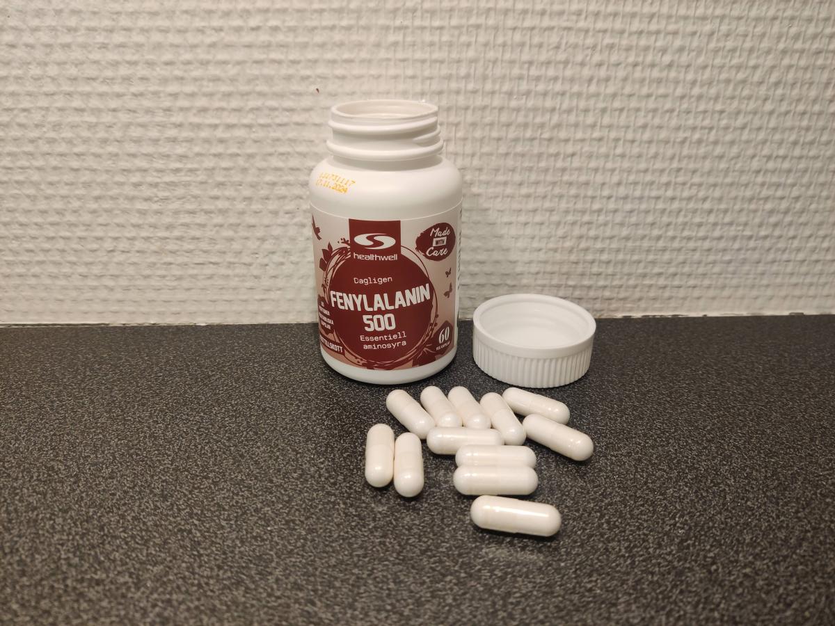 Kapslar från Healthwell Fenylalanin 500 utlagda på bänkskiva, egen testbild